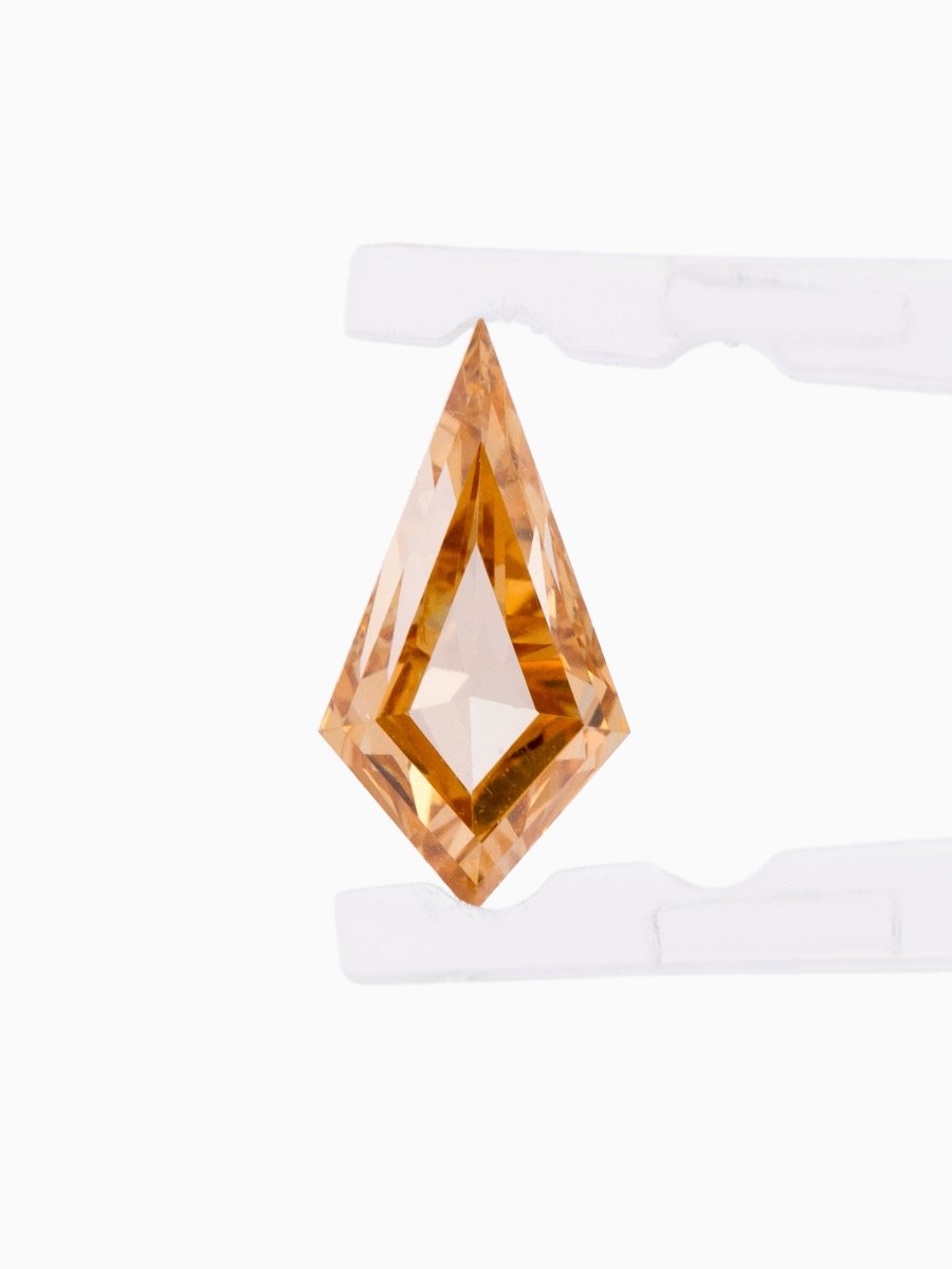 Loose kite-shaped champagne diamond with step cut, face view, held by tweezers