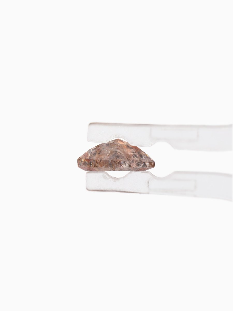 Side view of Loose kite-shaped rose salt and pepper diamond with autumn-colored inclusions, step cut, held by tweezers