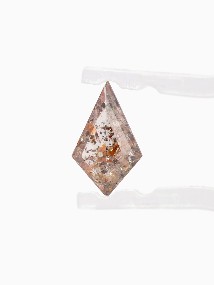 face view of Loose kite-shaped rose salt and pepper diamond with autumn-colored inclusions, step cut, held by tweezers