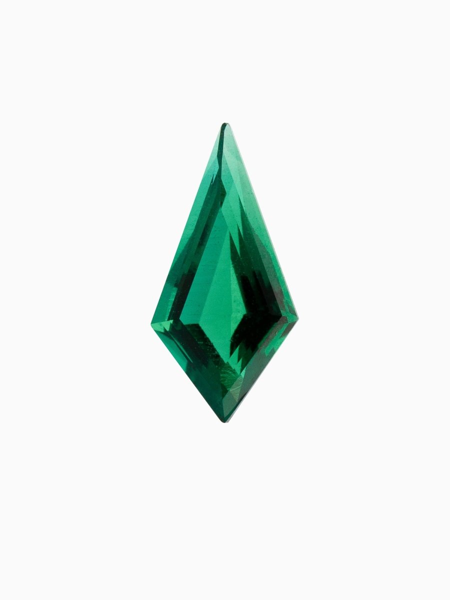 A kite-shaped, green emerald gemstone against a white background.