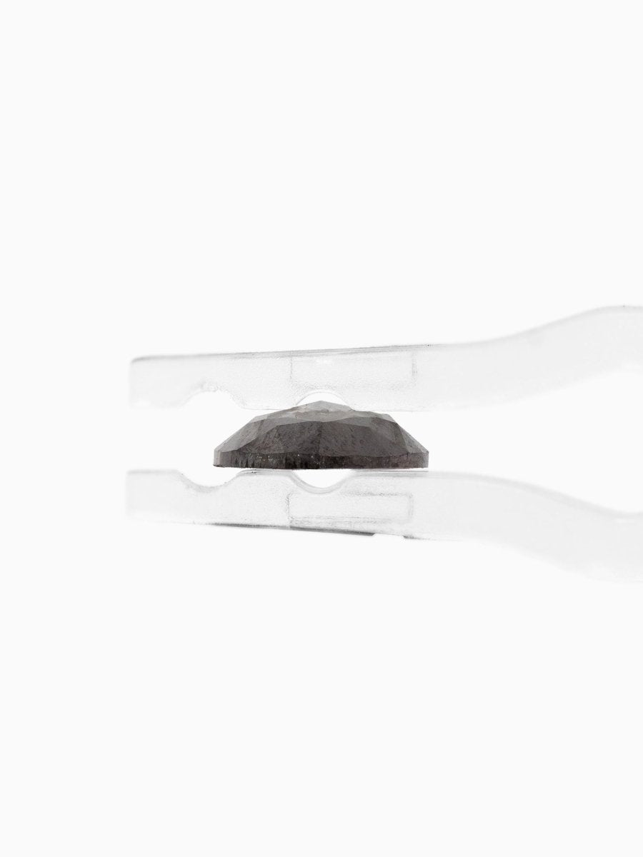 profile view of loose lab-grown marquise salt pepper diamond gemstone held by tweezers