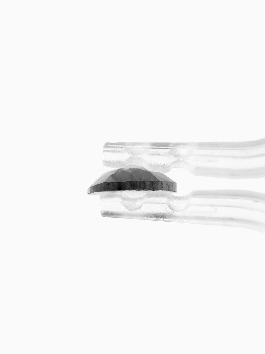 side view of loose lab-grown pear salt pepper diamond gemstone, held by tweezers