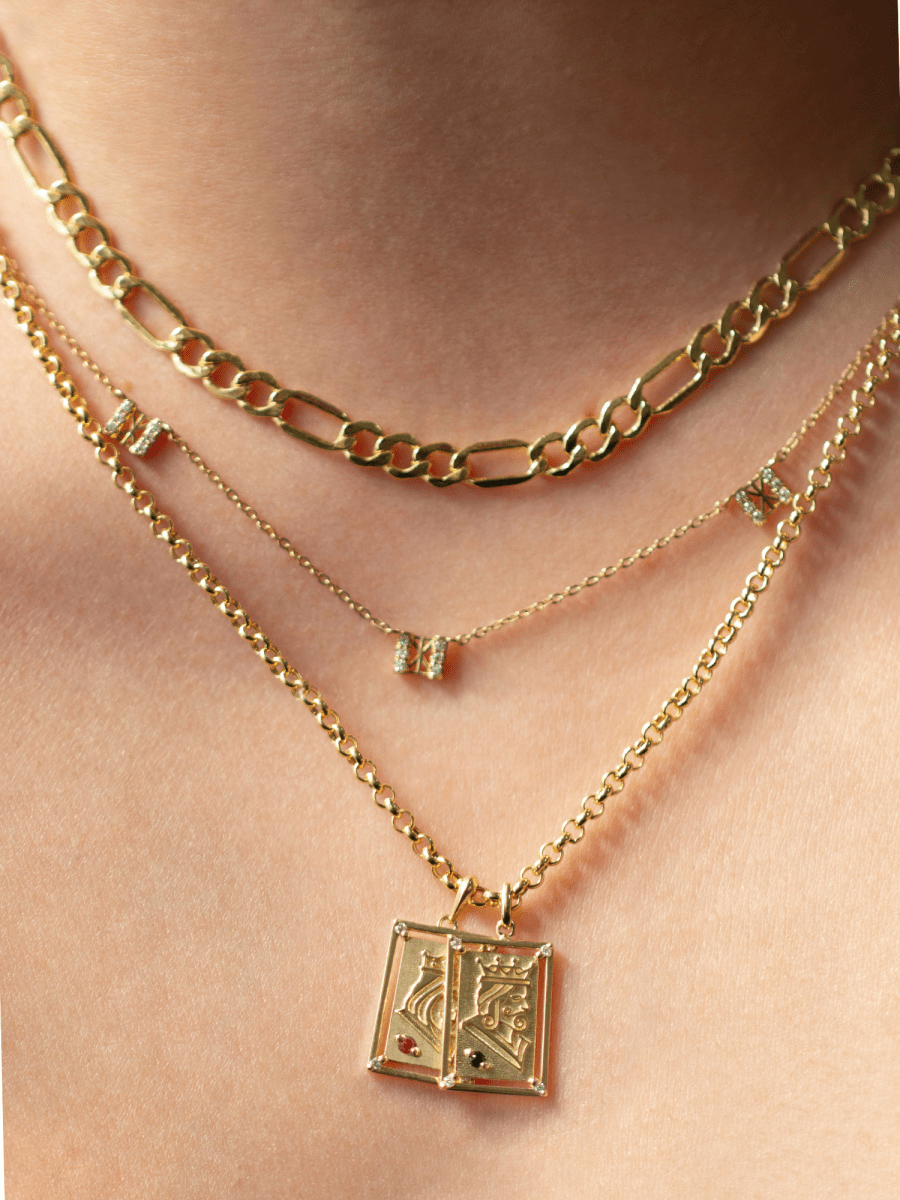 gold necklaces and playing card charms on neck