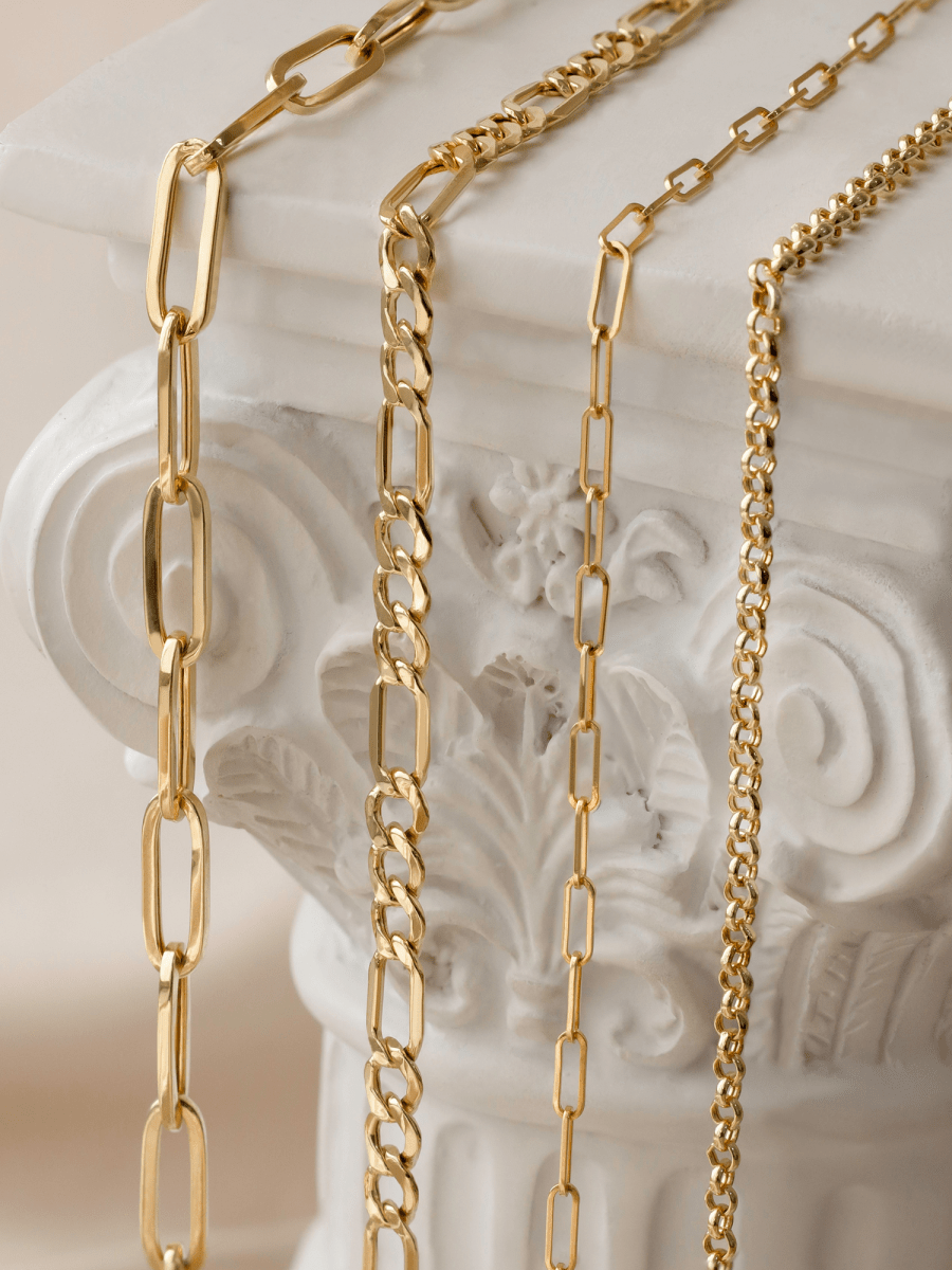 assorted chains laid on top of white Corinthian column