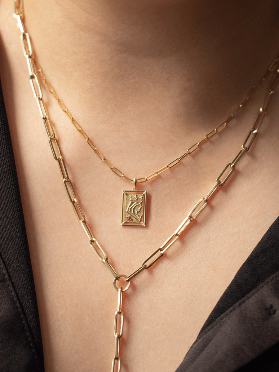 gold paperclip chains and playing card charm on neck