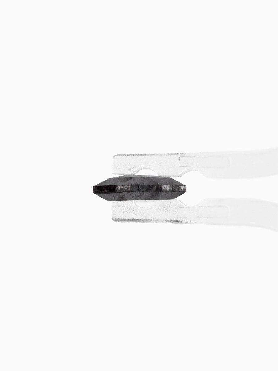 profile view of loose lab-grown hexagon salt pepper diamond gemstone held by tweezers