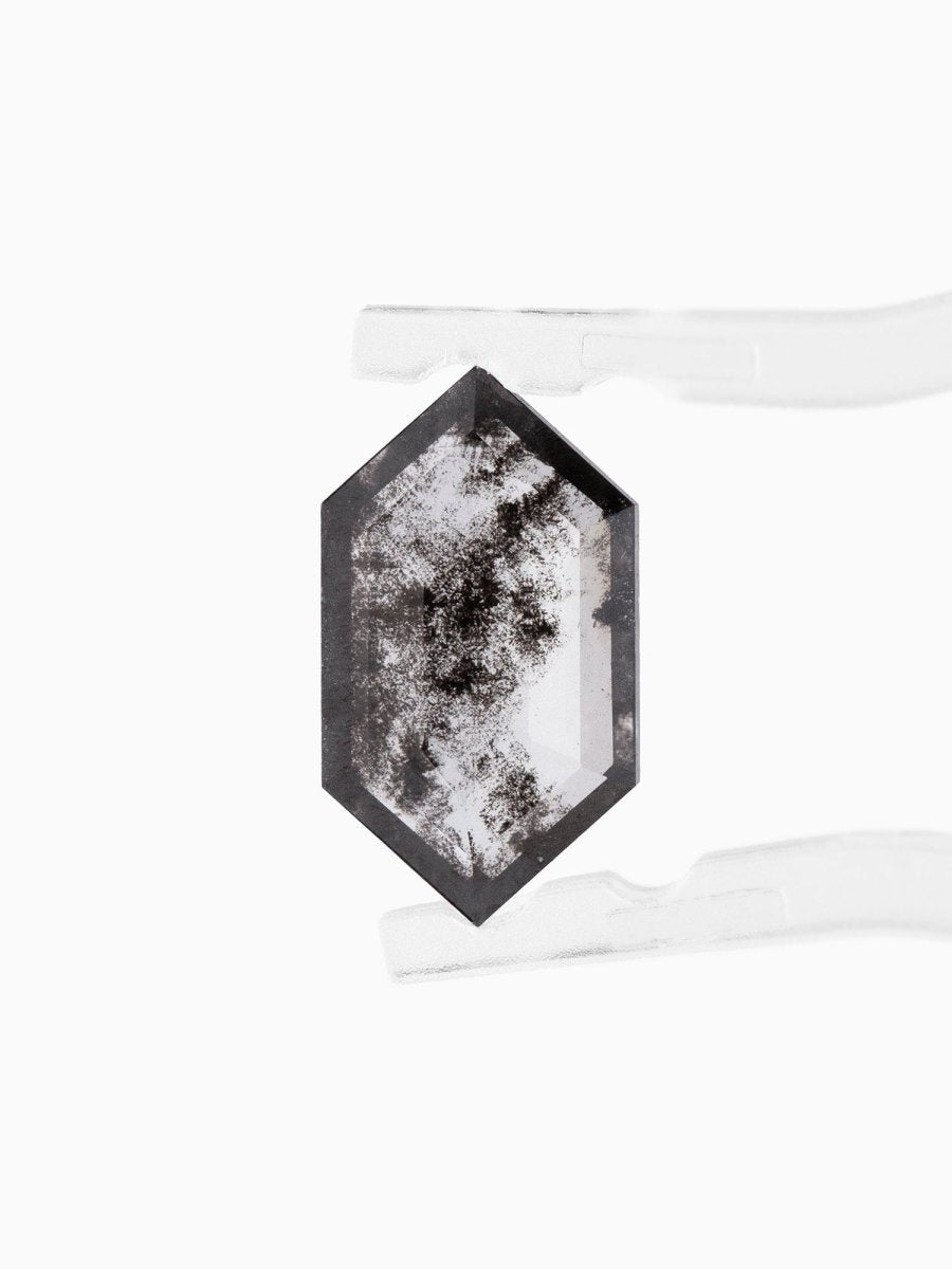 face view of loose lab-grown hexagon salt pepper diamond gemstone held by tweezers