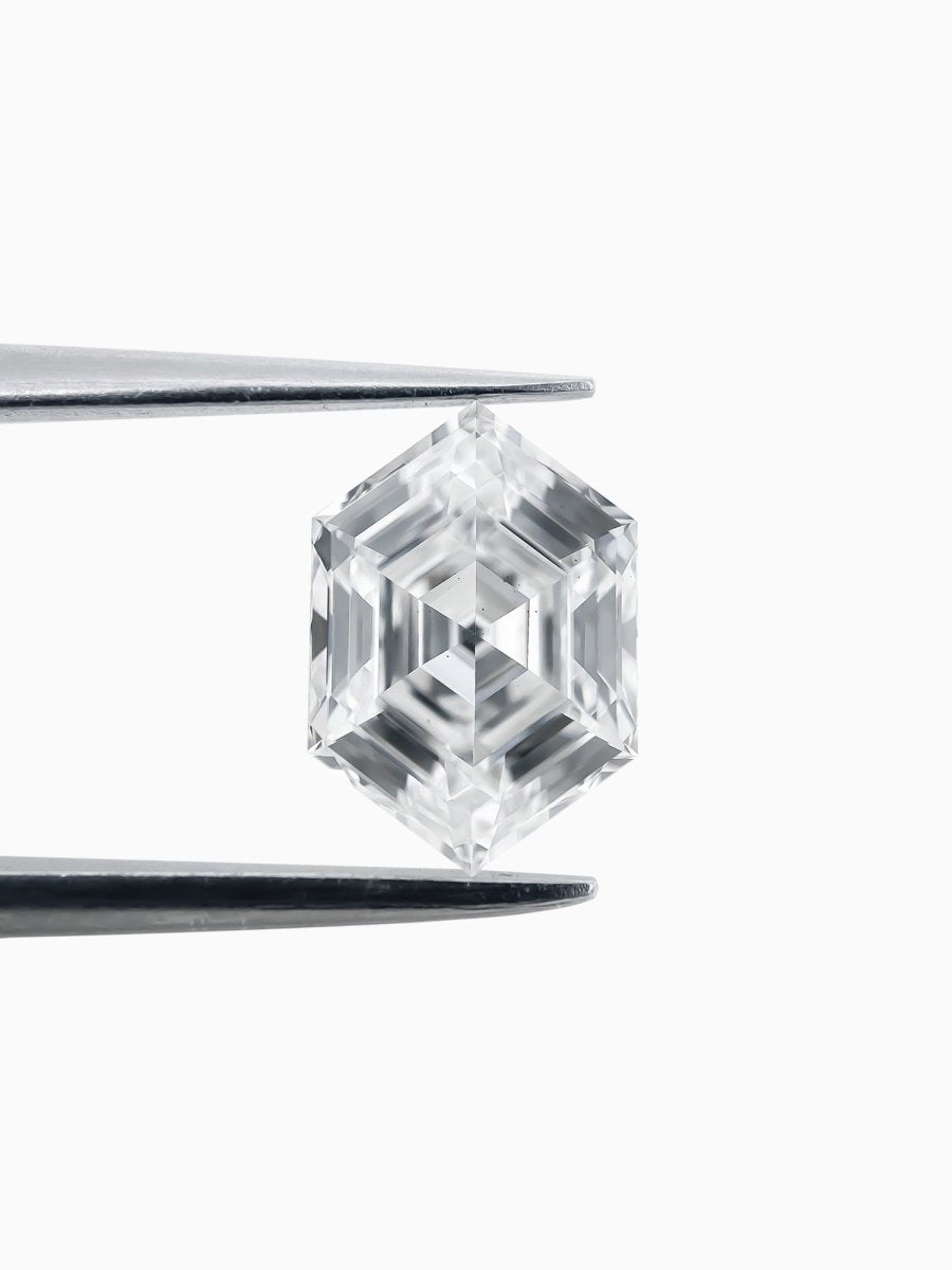 hexagon lab grown white diamond on a white background held by tqeezers