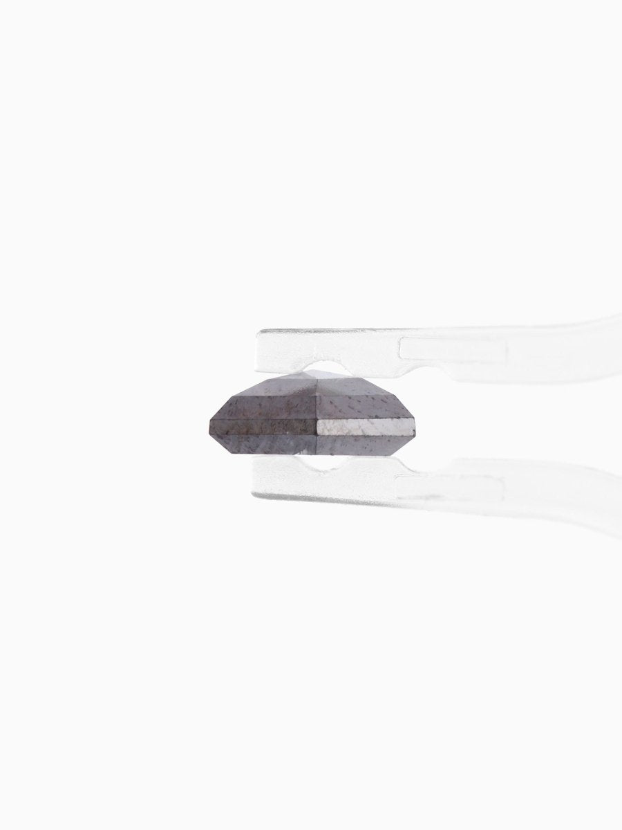 side view of loose lab-grown hexagon salt pepper diamond gemstone between tweezers