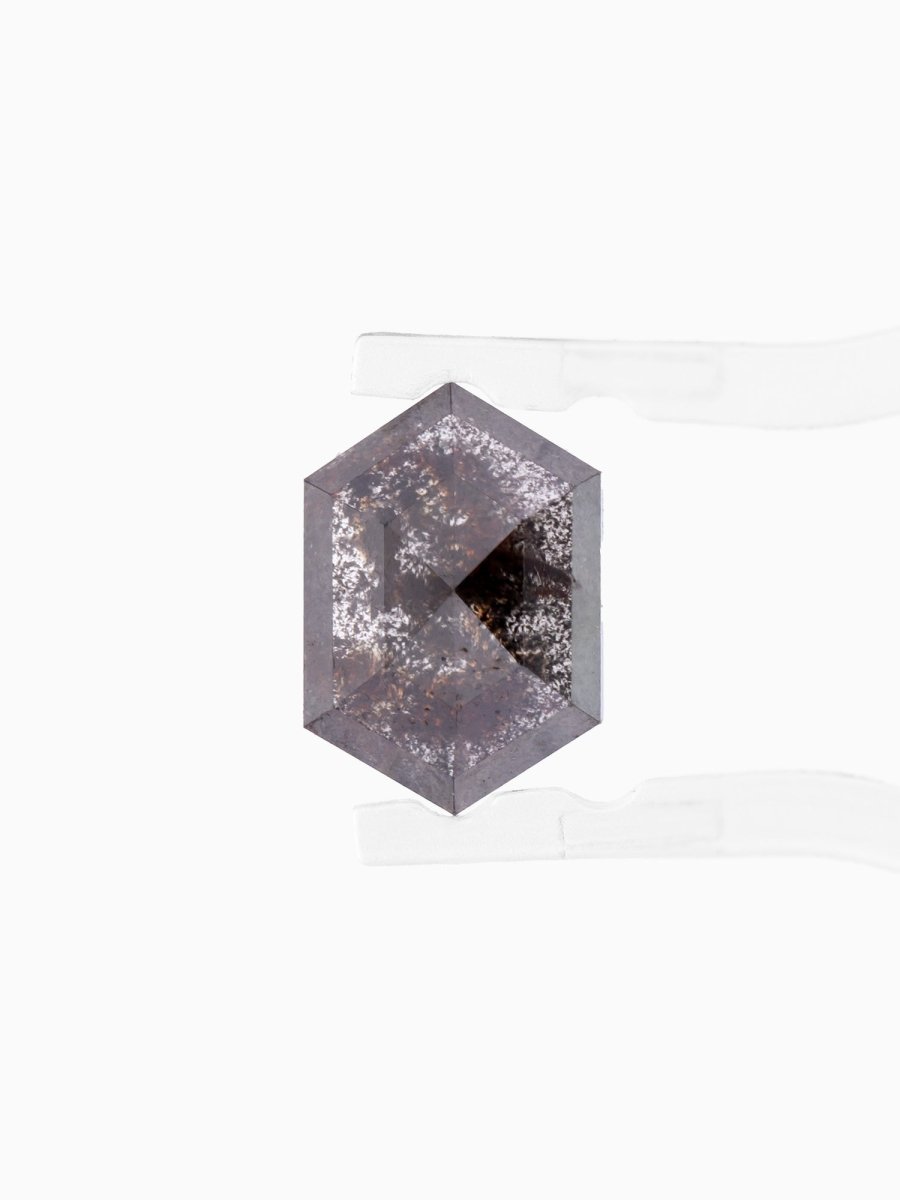 face view of loose lab-grown hexagon salt pepper diamond gemstone between tweezers