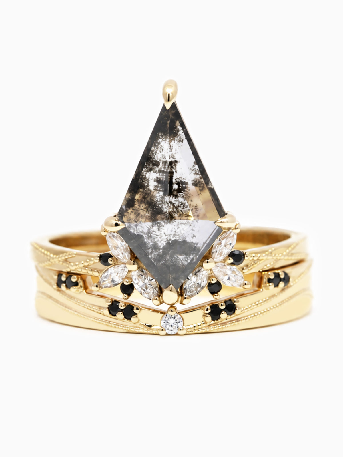A gold ring featuring a large triangular clear gemstone with black inclusions, surrounded by smaller clear and black stones on a textured gold band.