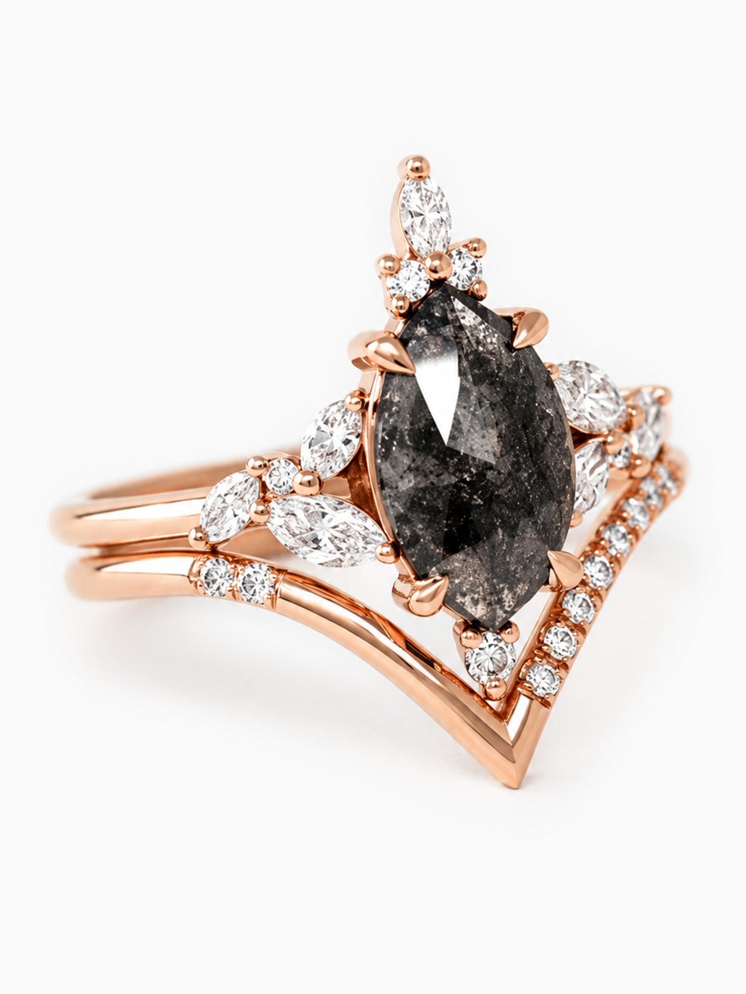 Rose gold ring with a central black diamond and smaller clear diamonds on a white background