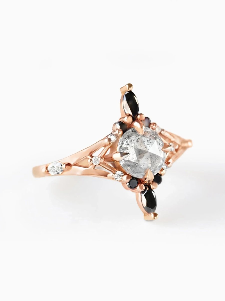 Rose gold ring with a large diamond and smaller stones on a white background
