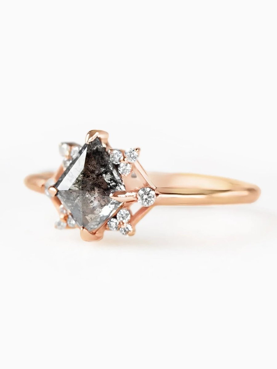 Rose gold ring with a large diamond and smaller diamonds on a white background