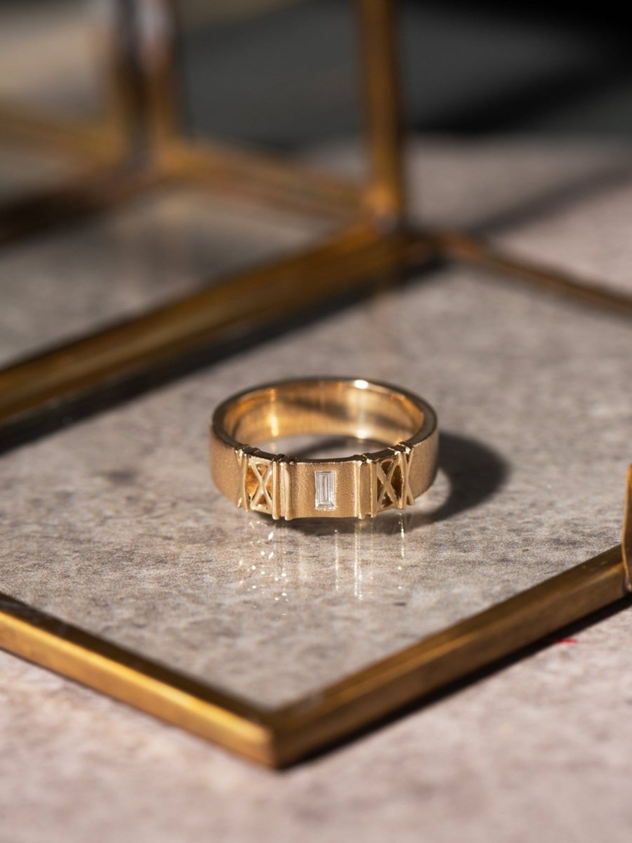 Gold ring with a stone on a reflective surface