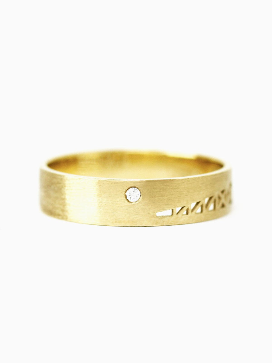 Gold ring with mountain design on a white background