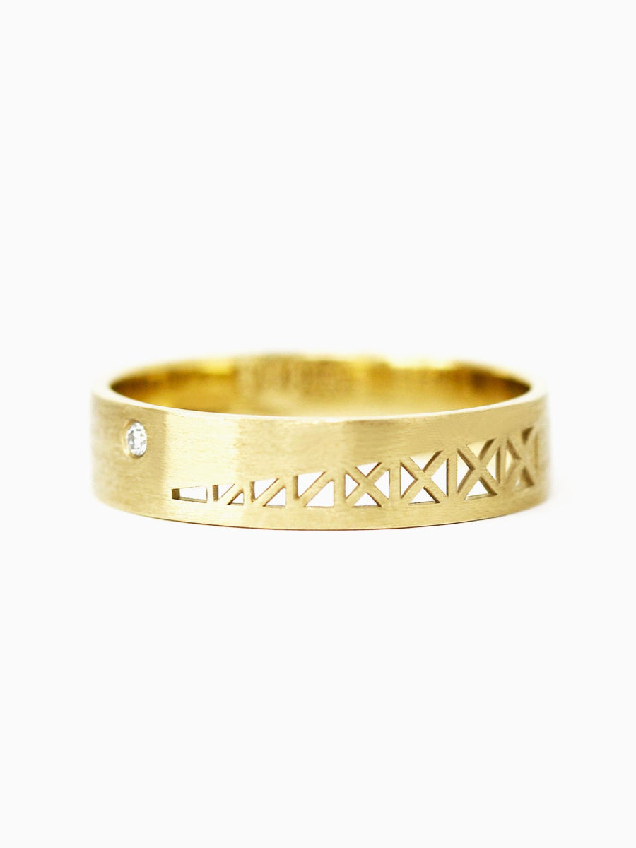 Gold ring with geometric design on a white background