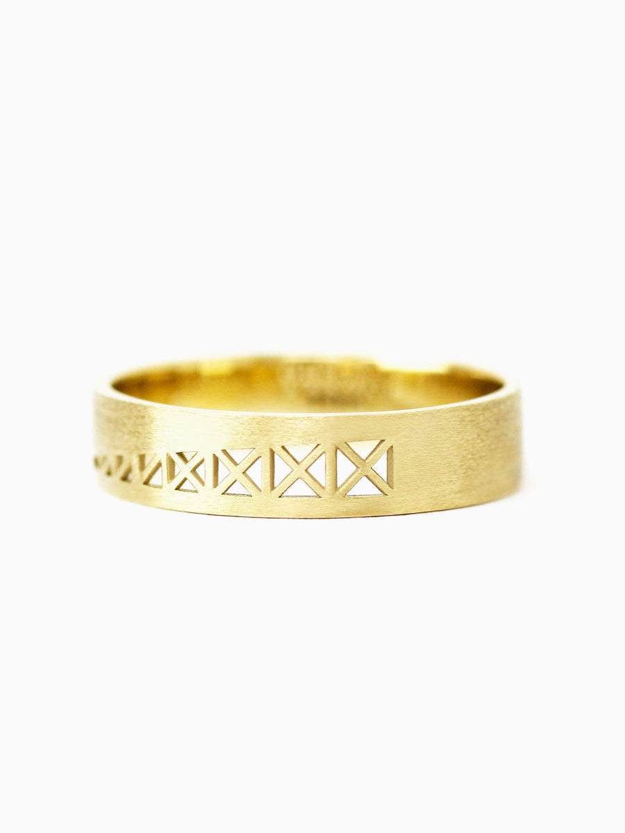 Gold ring with geometric design on a white background