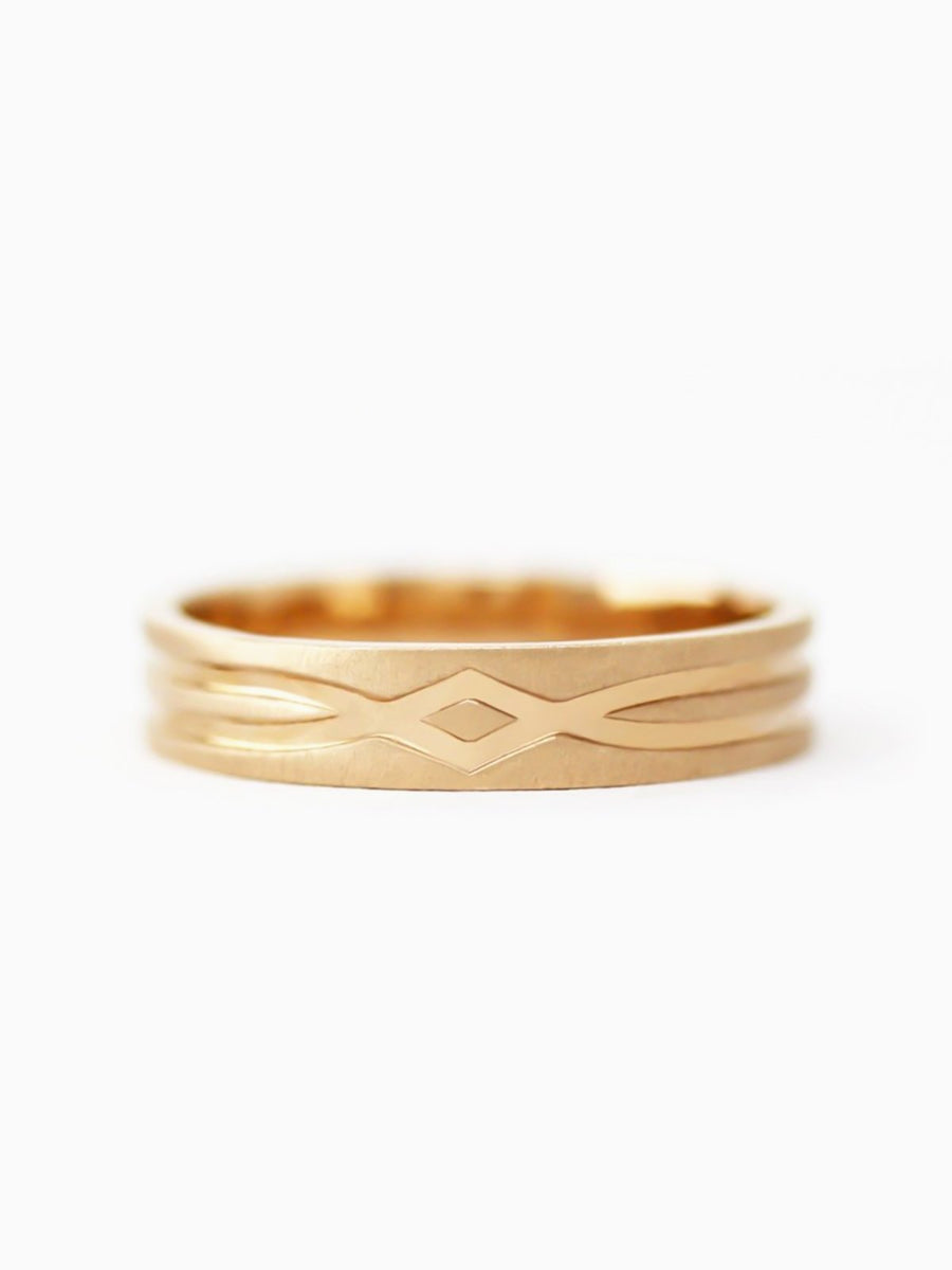 Gold ring with intricate design on a white background
