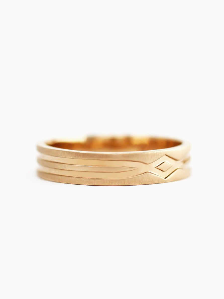 Gold ring with a subtle design on a white background