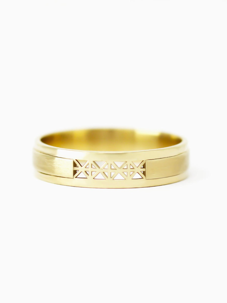 Gold ring with geometric design on a white background