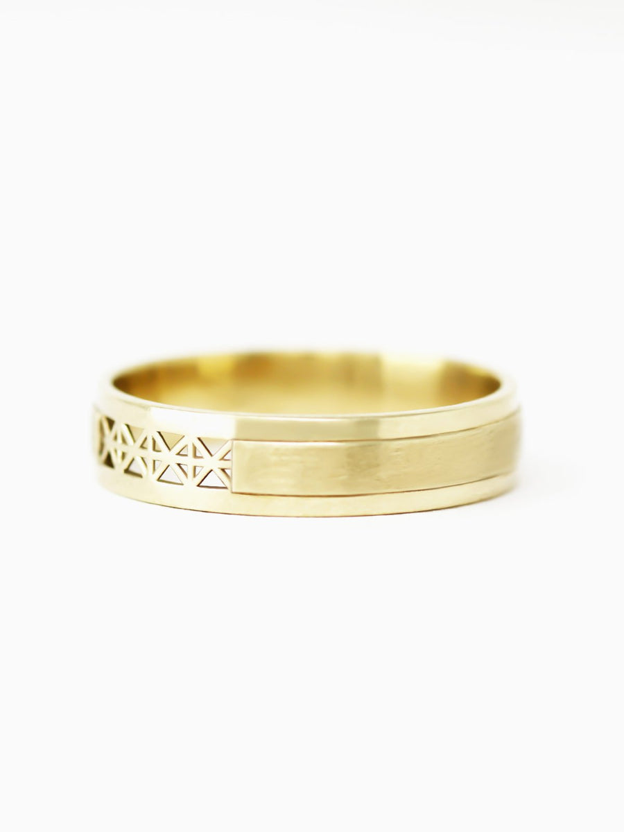 Gold ring with geometric design on a white background