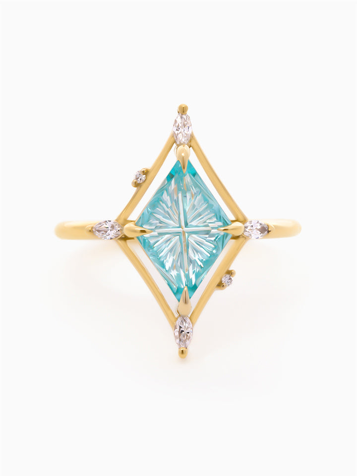 Gold ring with a star-shaped blue gemstone on a white background
