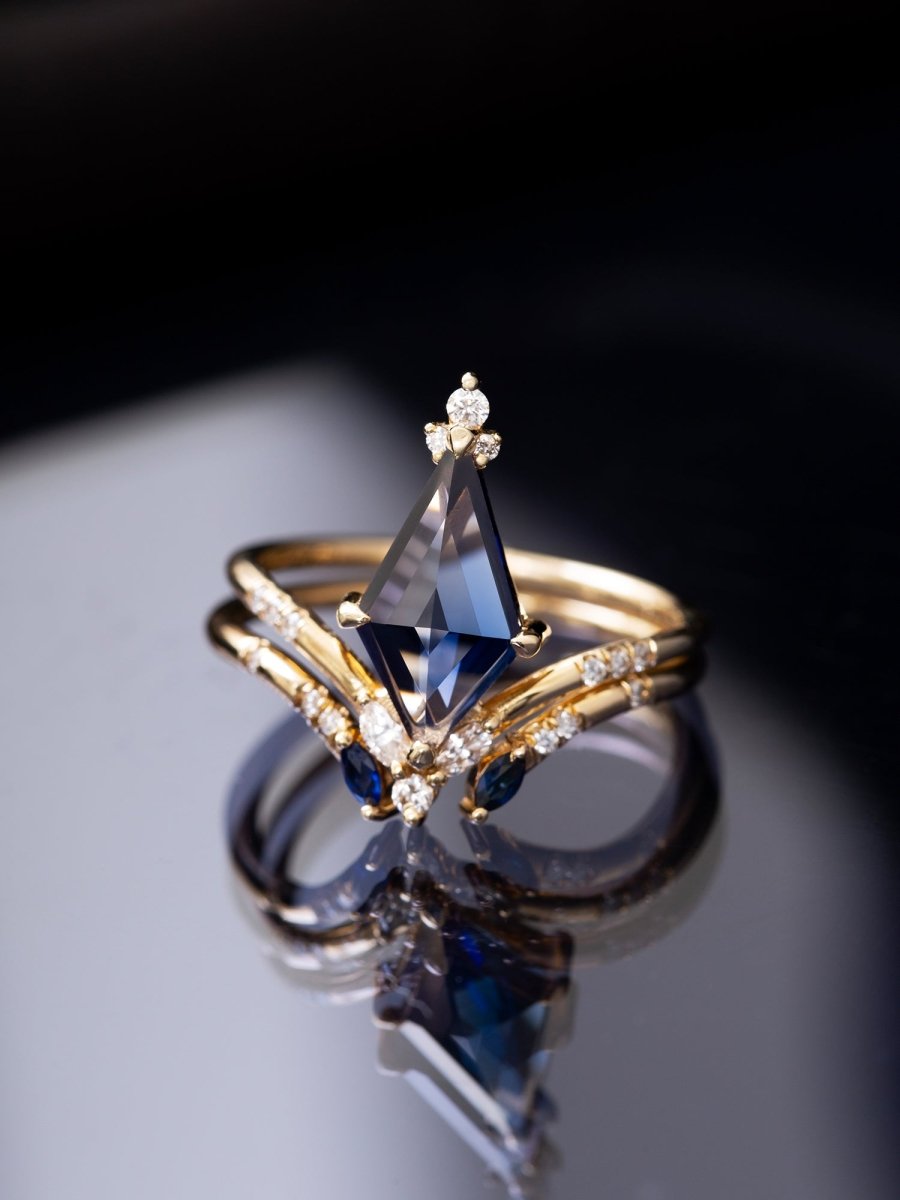 Gold ring with a blue gemstone on a reflective surface