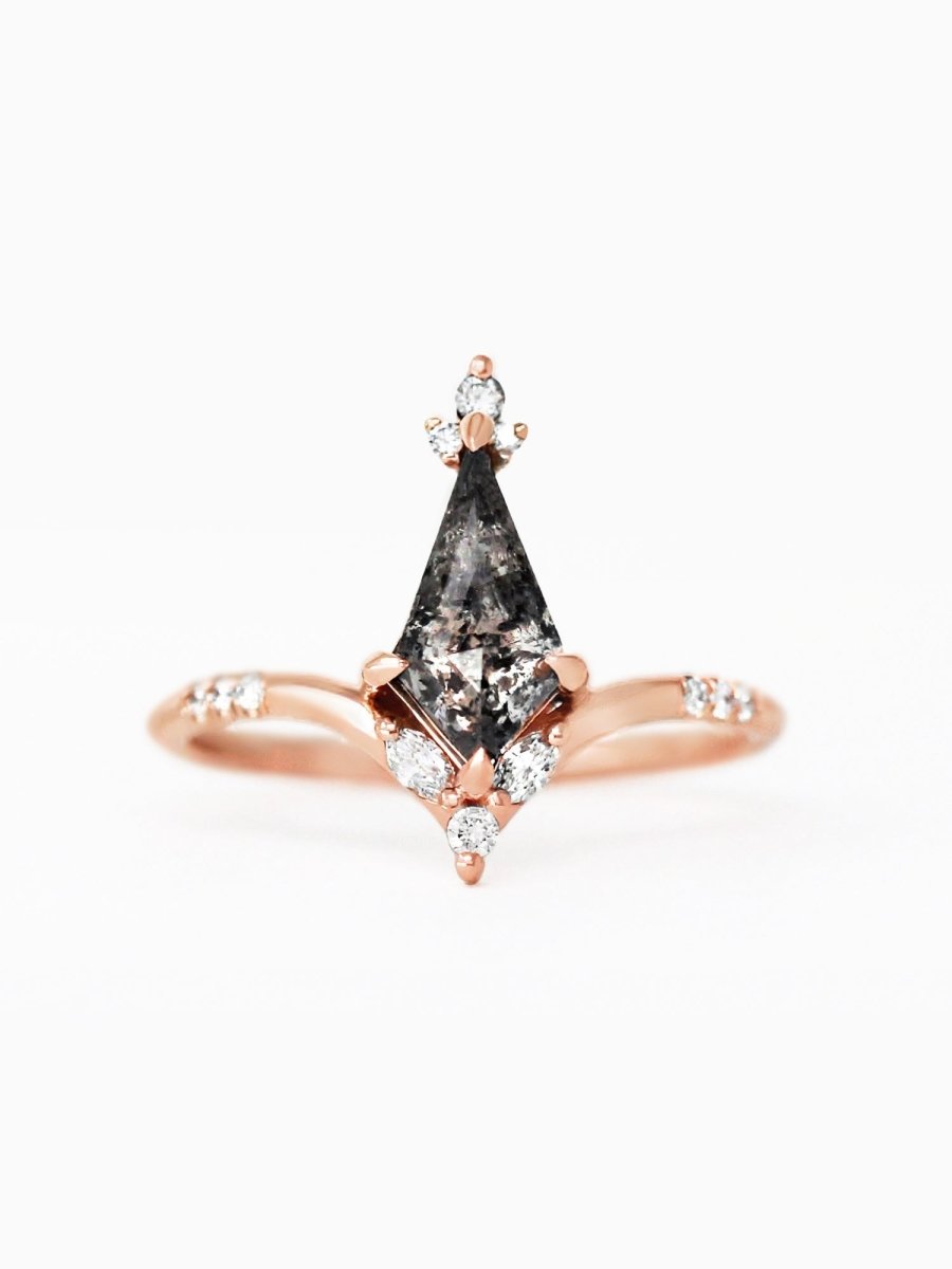 A rose gold engagement ring with a salt and pepper diamond centerpiece and symmetrical diamond accents along the band.