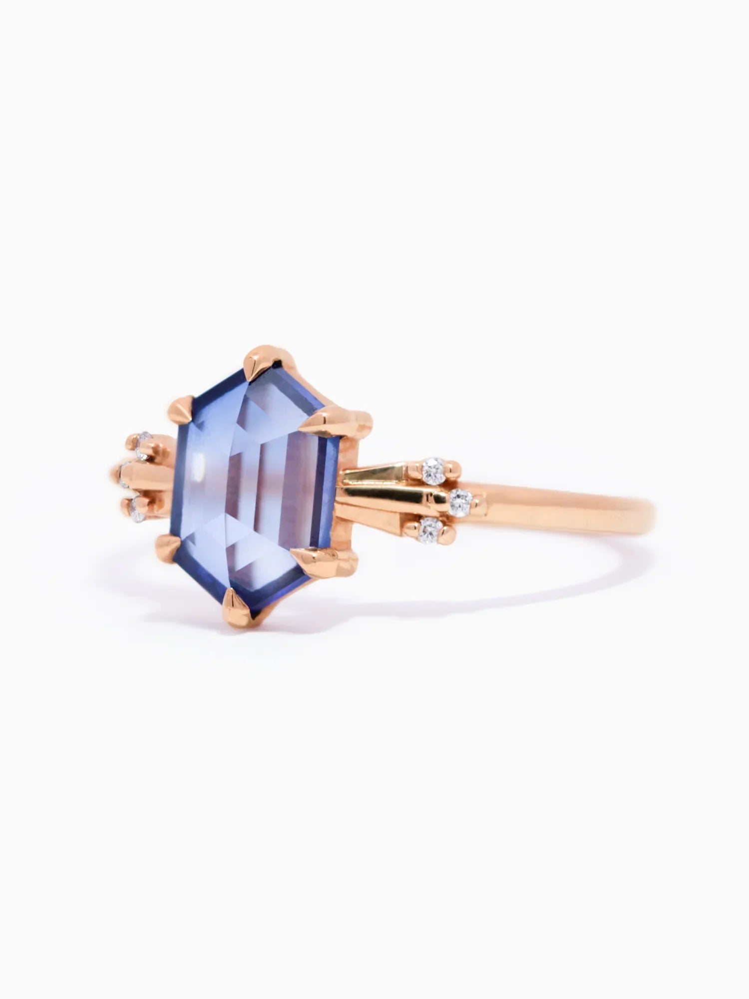 Rose gold ring with a blue gemstone on a white background