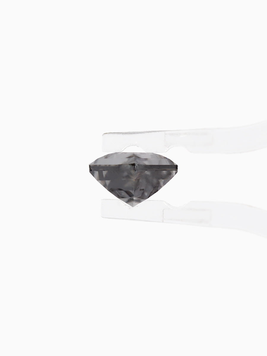 Black kite shaped moissanite held by tweezers, side view