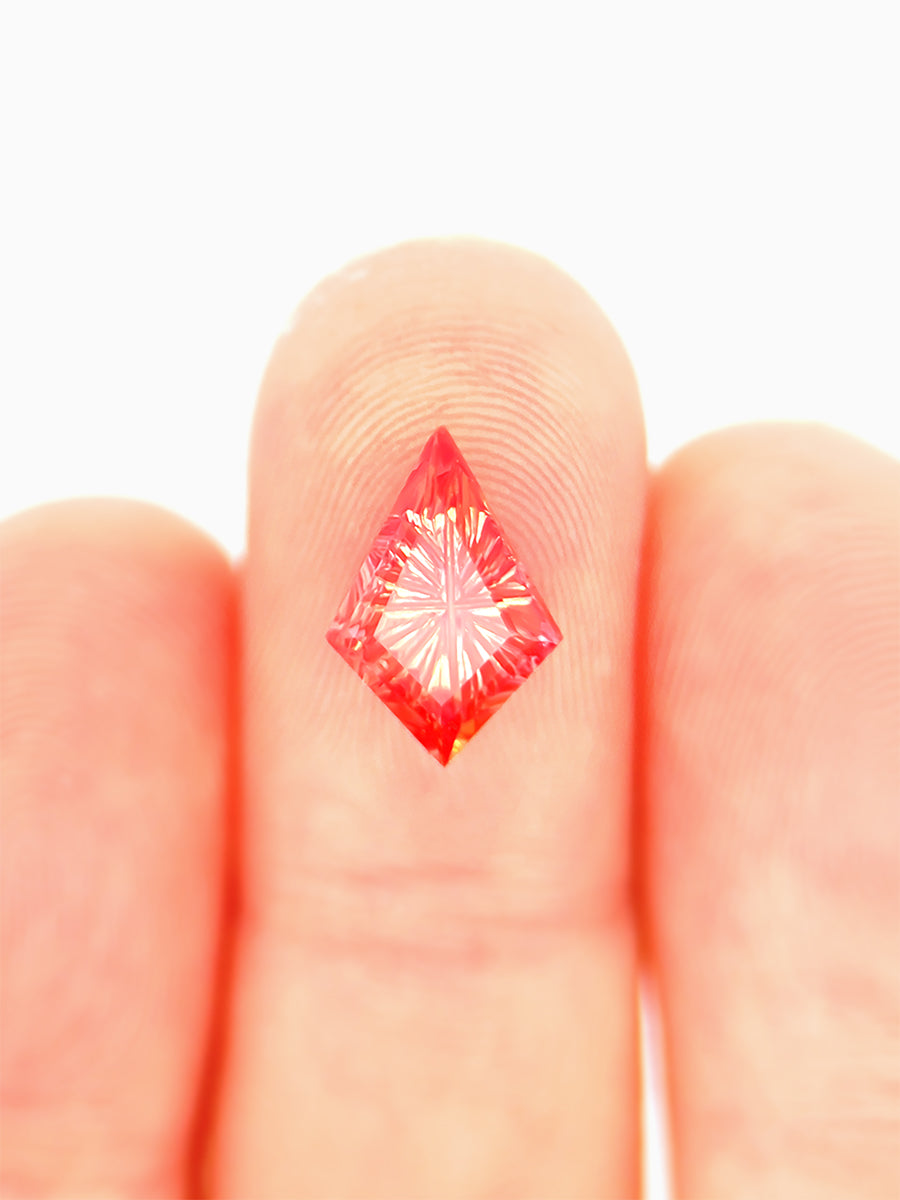 lab grown fantasy cut red sapphire kite on finger to show scale