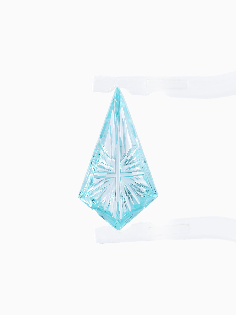 lab grown fantasy cut teal sapphire kite held by tweezers, focusing on radiating faceted pavilion