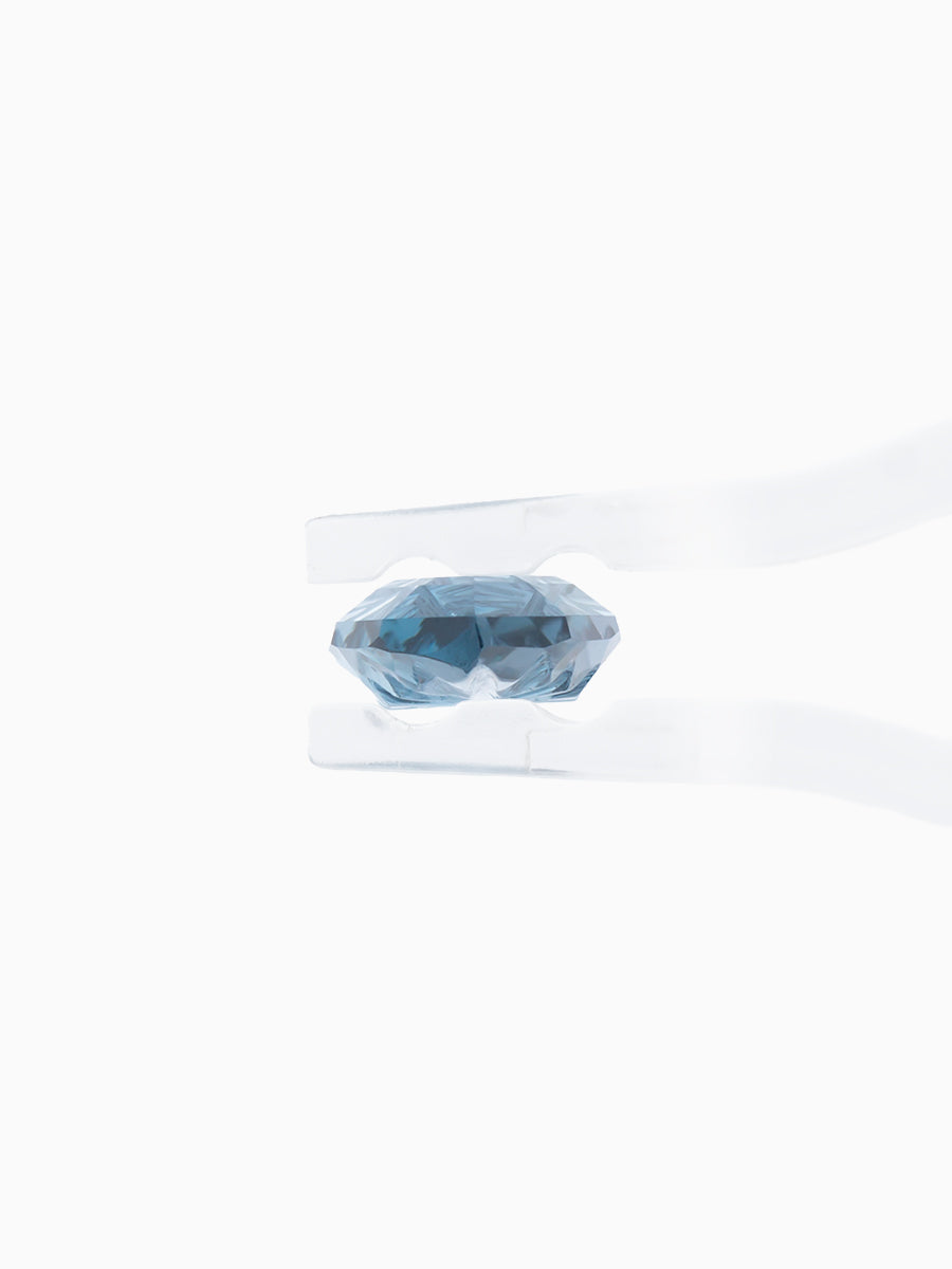 sky blue marquise garnet with sunbursts cut into its pavilion held by tweezers, side view
