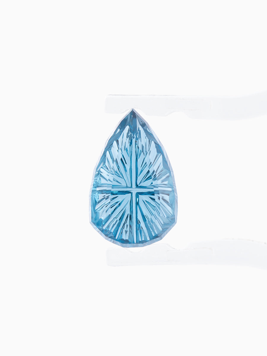 sky blue pear garnet with sunbursts cut into its pavilion held by tweezers, face view