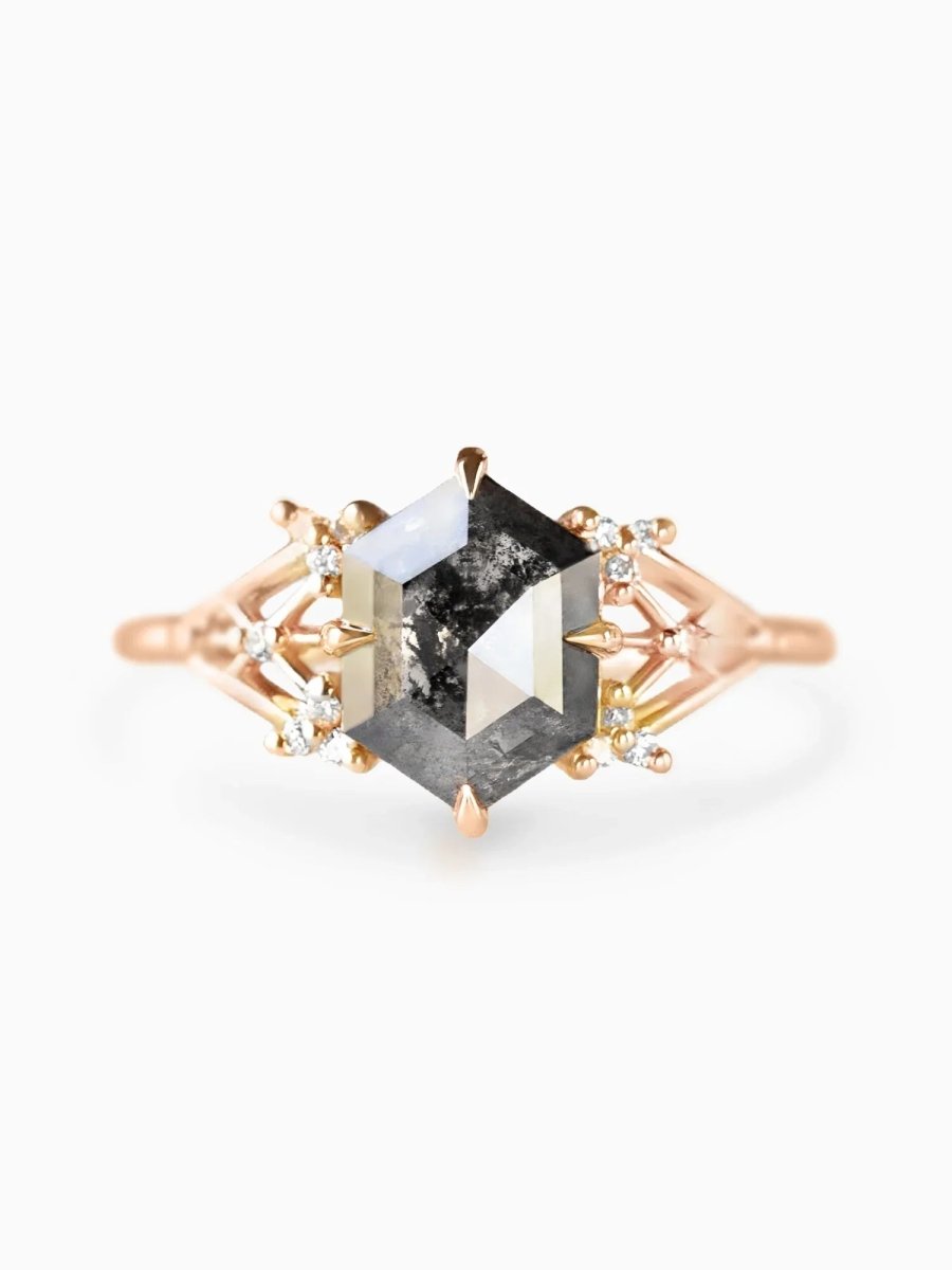 Rose gold ring with a large black diamond and smaller clear stones on a white background