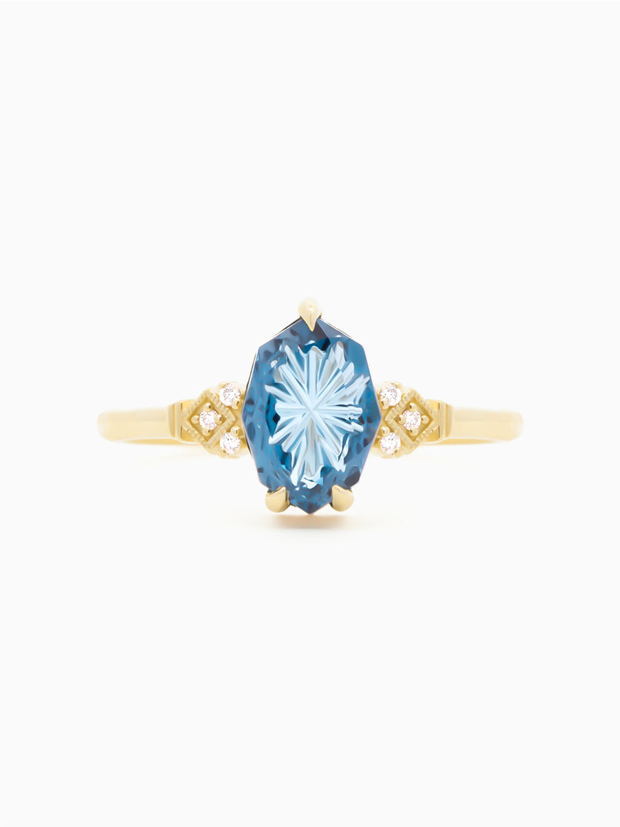Gold ring with a blue starbrite sapphire on a white background. front view