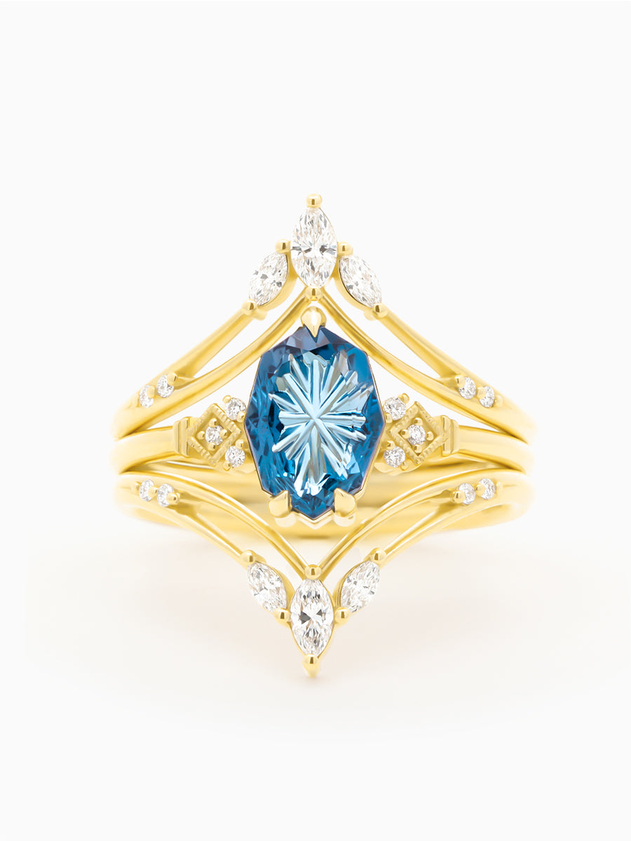 Gold ring with a blue gemstone and diamonds on a white background