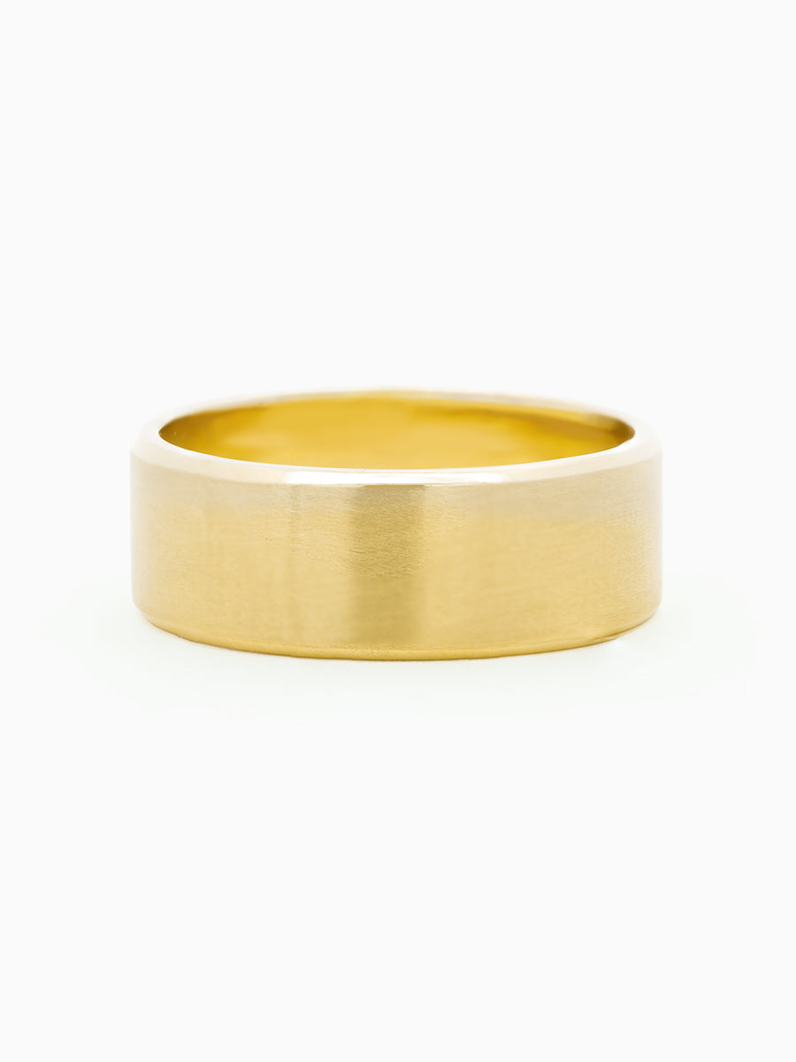 Men's solid gold wedding band on white background