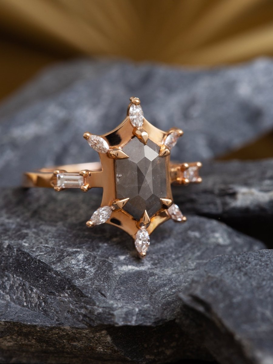 Gold ring with a central diamond and smaller diamonds on a dark stone surface