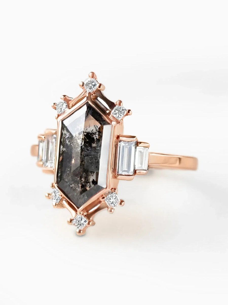 Rose gold ring with a large central gemstone and smaller diamonds on a white background