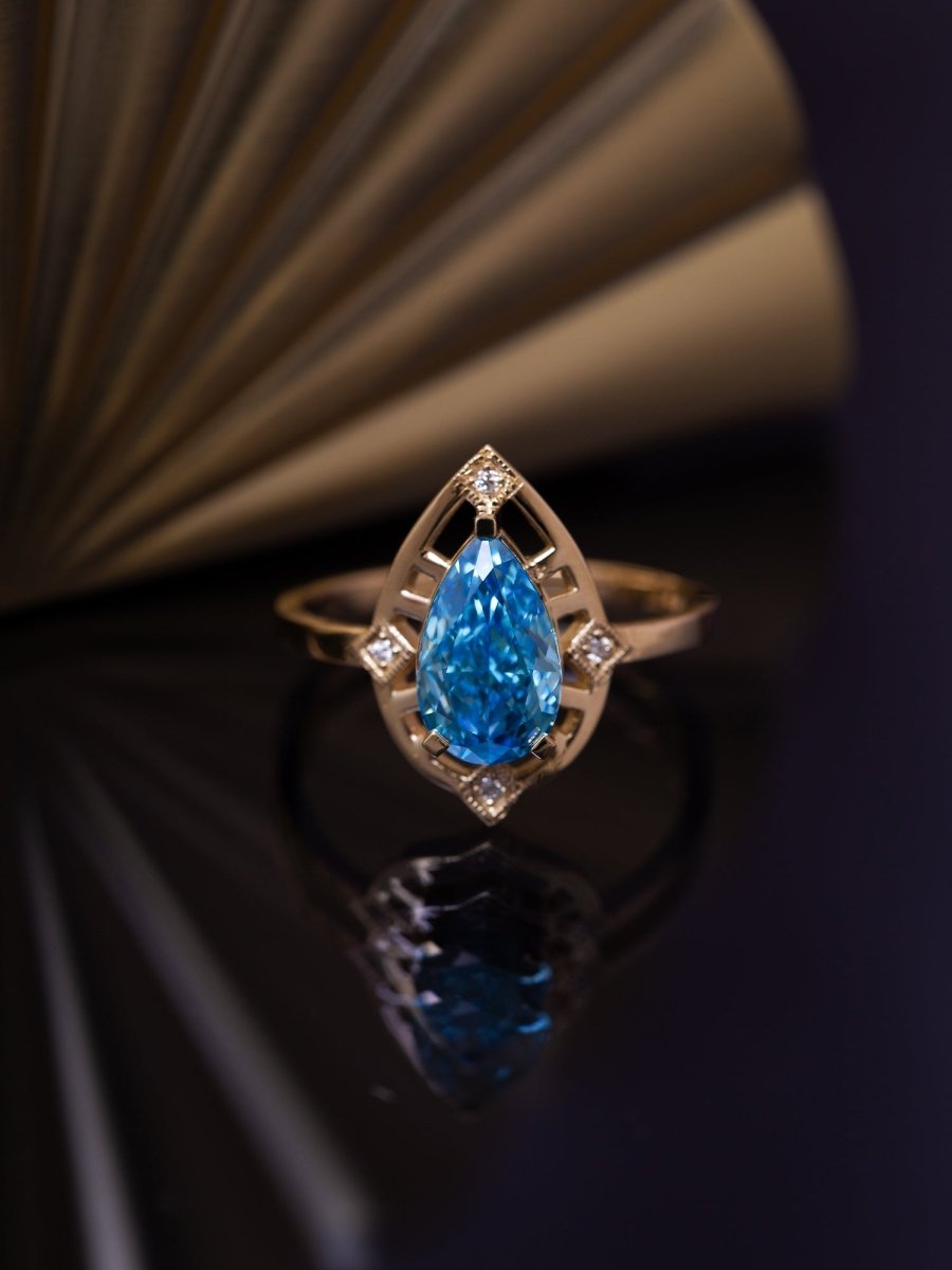 Gold ring with a blue diamond on a dark background
