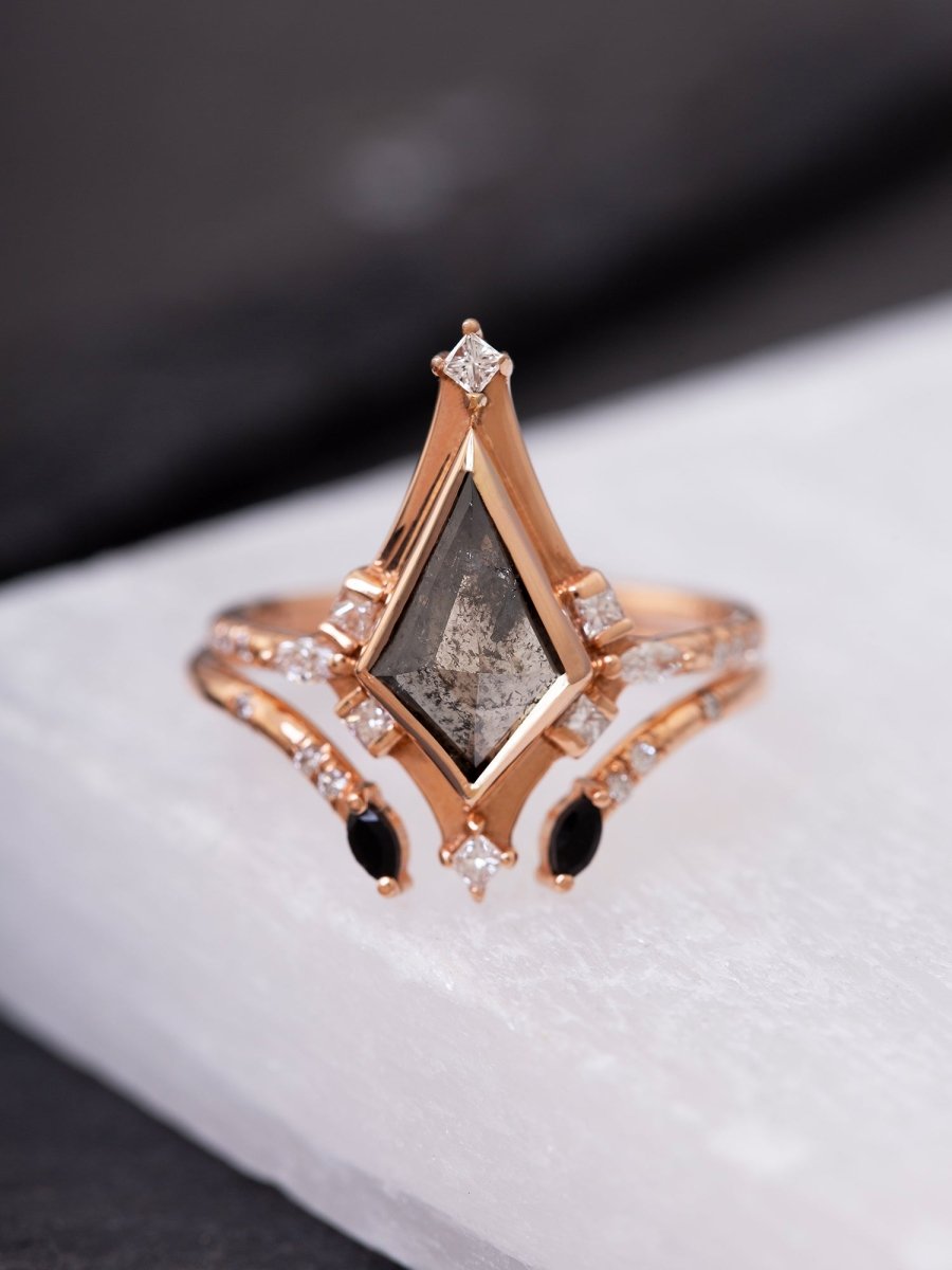 Rose gold ring with a central diamond and smaller stones on a white surface