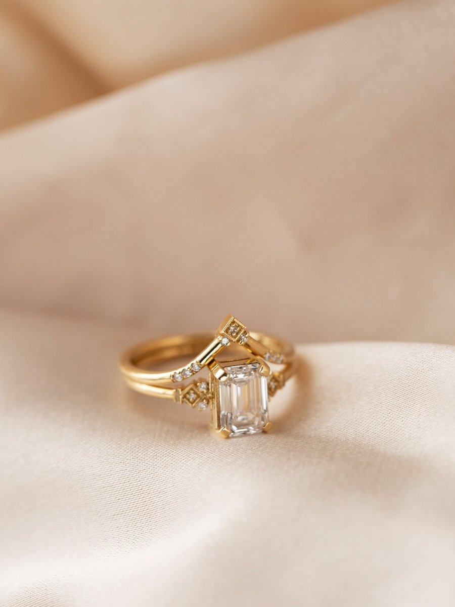Gold ring with a diamond on a beige fabric background