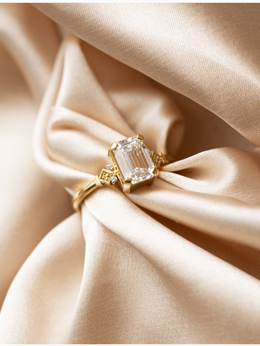 Gold ring with a large diamond on beige fabric