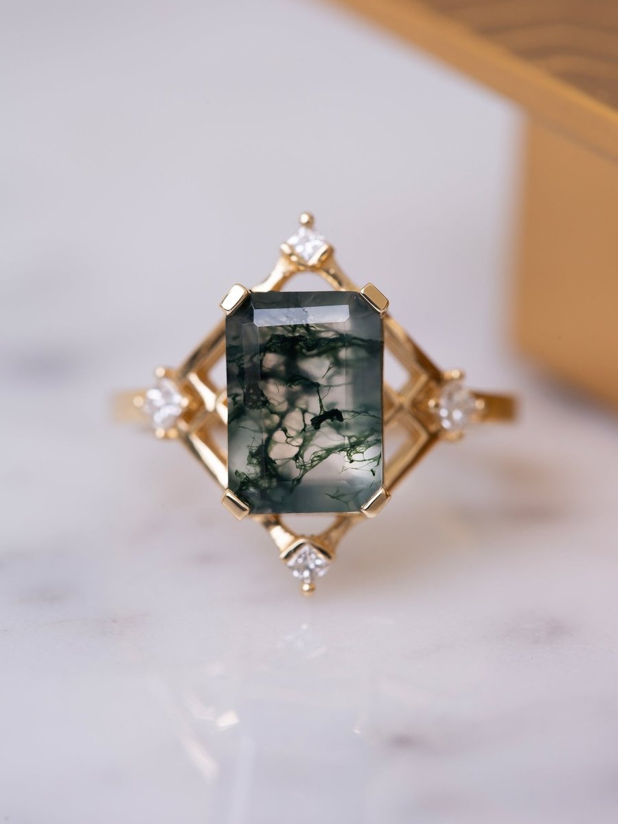 Gold ring with a green gemstone on a white background