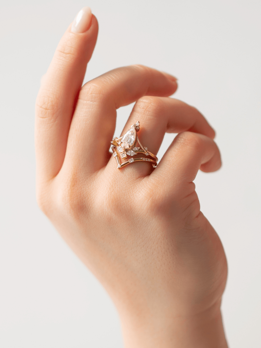 hand wearing Art Nouveau engagement ring with marquise diamond, split shank, and chevron contour band