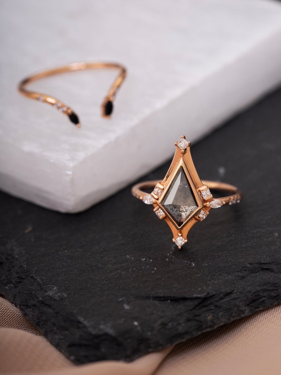 Rose gold ring with a diamond on a dark surface