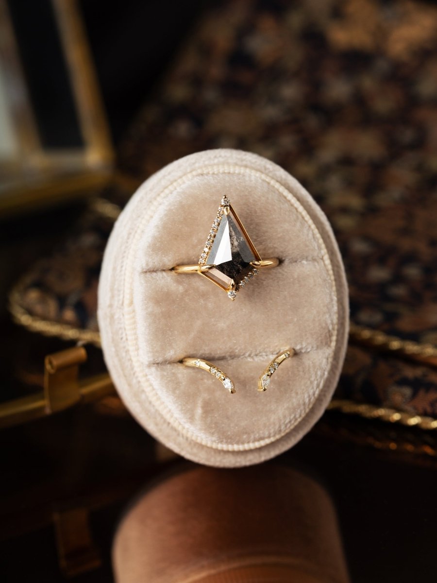 Three gold rings on a beige velvet cushion with a blurred background