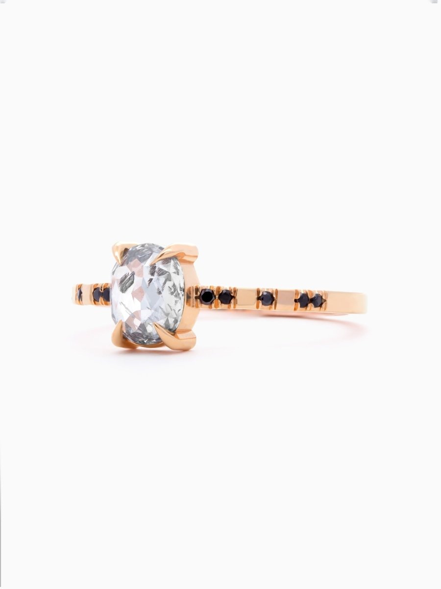 side view of rose gold ring with a large central salt pepper diamond with onyx gallery